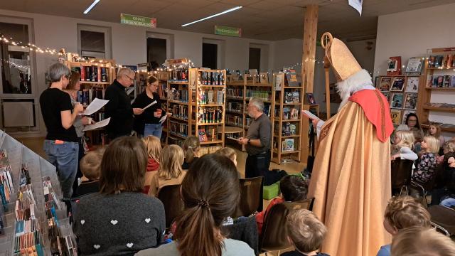 Nikolaus und Mitglieder des Bibliotheksteams "spielen" die Legende von Nikolaus und den drei armen Töchtern